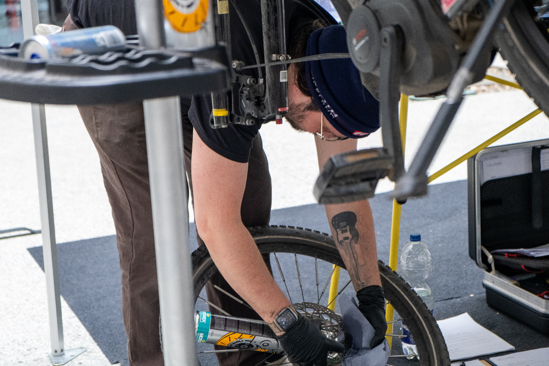 Mechaniker prüft die Hinterradbremse eines Mitarbeitenden-Fahrrads